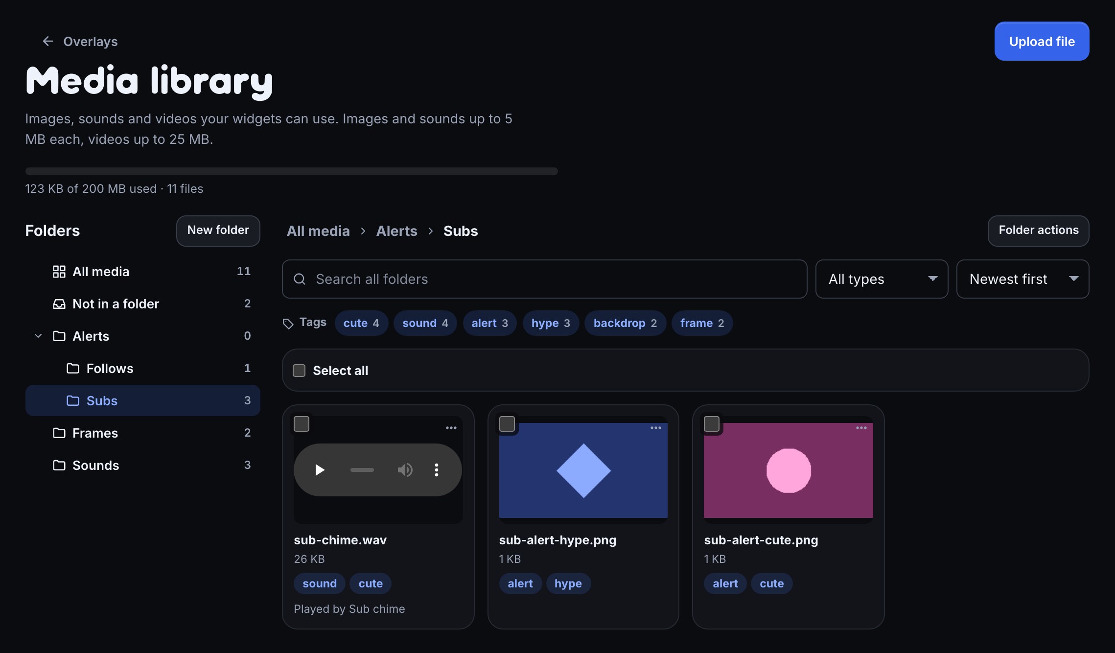 The Media library page with Alerts › Subs open: the Folders list with All media, Not in a folder, Alerts (Follows, Subs), Frames and Sounds and a file count beside each; the trail All media, Alerts, Subs; a search box, type and sort selects; tag chips cute, sound, alert, hype, backdrop and frame; and three files, each with its tags.